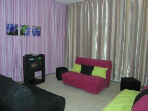 a living room with a red couch and a tv at Hostel Raiduzhny in Kharkiv