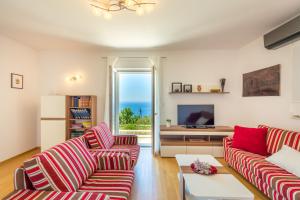 a living room with red and white striped couches and a television at Hedera Estate, Villa Hedera VII in Zaton