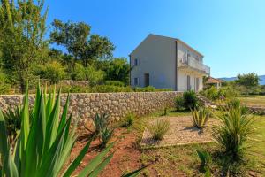 a house with a stone fence and a stone wall at Hedera Estate, Villa Hedera VII in Zaton