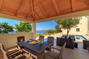 a patio with a table and chairs and a pool at Villa Hedera VII in Zaton