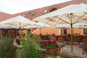 a patio with white umbrellas and tables and chairs at Hotel Pavlov in Pavlov