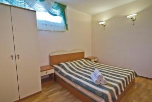 1 dormitorio con 1 cama con 2 toallas en Guest House Edem, en Sudak