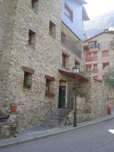 ein Steingebäude mit einer grünen Tür und einer Treppe in der Unterkunft P&C Font Verd in Canillo