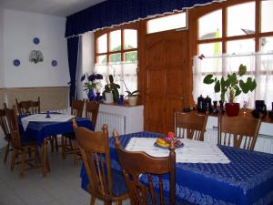 a dining room with two tables and chairs and windows at Haus Martha in Balatonudvari