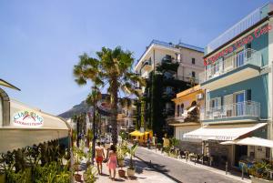 a group of people walking down a street with buildings at Ciao Ciao Rooms in Letojanni