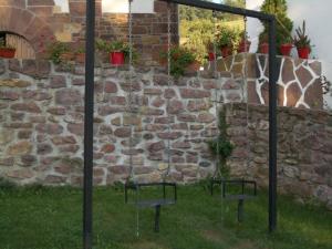 two chairs in front of a stone wall at Martintzenea in Sumbilla
