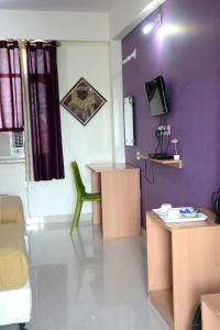 a room with purple walls and a table and a chair at Hotel Bodh Vilas in Bodh Gaya