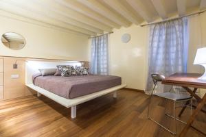 un dormitorio con una cama y un escritorio en Apartments Moon or Dama, en Venecia