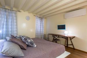 Un dormitorio con una cama, una mesa y un escritorio. en Apartments Moon or Dama, en Venecia 7 fotos más