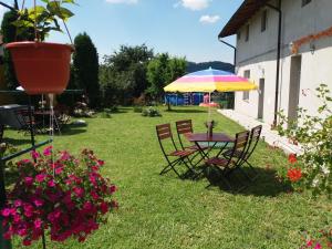 a table and chairs with an umbrella in a yard at Casa Ariana in Curtea de Argeş