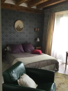 um quarto com uma cama, um sofá e uma cadeira em La ferme de Félix em La Chaze-de-Peyre