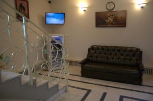 a living room with a couch and a clock on the wall at Pensiune Xe-Mar in Arad
