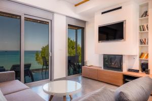 a living room with a fireplace and a tv at Sunrise Rent Rooms in Amoudi