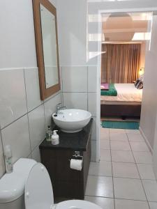 a bathroom with a sink and a toilet and a mirror at JS Inn in Nelspruit