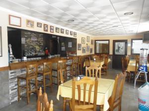 a restaurant with tables and chairs and a bar at Hostal Paquito in Vejer de la Frontera