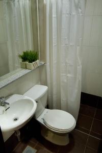 La salle de bains est pourvue de toilettes blanches et d'un lavabo. dans l'établissement Hotel Stella, à Cebu
