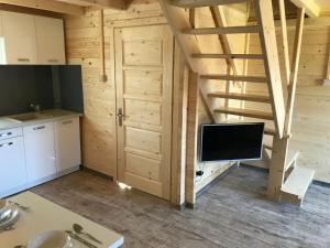 a kitchen with a tv in a wooden room at Domki na Morskiej in Łukęcin