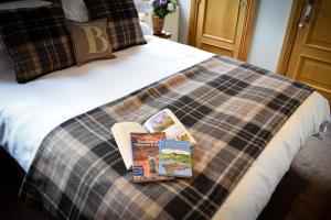 a bed with two books on top of it at Benoch Lomond Castle in Alexandria
