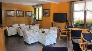 a waiting room with chairs and a table and a tv at Hotel De Rei in Llavorsí