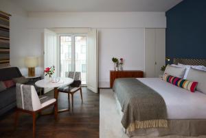 里斯本The Lumiares Hotel & Spa - Small Luxury Hotels Of The World的一间带大床的卧室和一间客厅