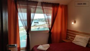 Un dormitorio con una ventana con vista a un edificio. en Hotel Lozite, en Sozopol