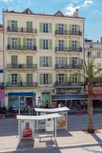 un gran edificio con una palmera delante en Florella Jean Jaures Apartment en Cannes