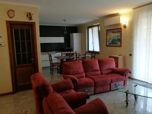 a living room with a red couch and a table at Pellico Apartment in Brusaporto