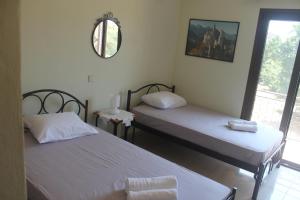 two twin beds in a room with a mirror at Villa Bene in Preveza
