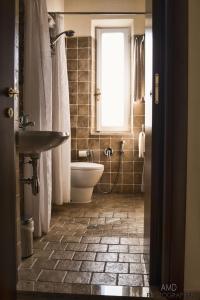 a bathroom with a sink and a toilet and a window at Los Flamingos in La Maddalena