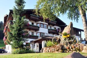 um edifício com uma bicicleta estacionada em frente em Sport und Familienhotel Klausen em Kirchberg in Tirol