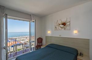 a bedroom with a bed and a view of the ocean at Hotel Rialto Suisse in Lido di Camaiore