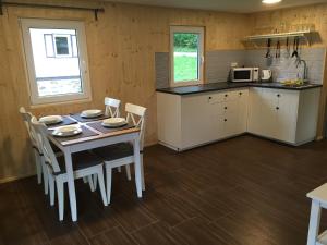 a kitchen with a table and chairs and a microwave at Penzion Nike TRIO RIVIERA in Jedovnice