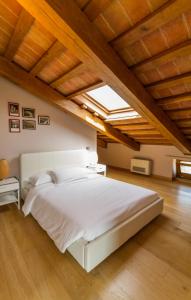 a bedroom with a large white bed with a skylight at Tenuta Borgo Santa Cecilia in Brunetta