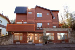 a large wooden house with a lot of windows at Balcones del Sayhueque in Villa La Angostura