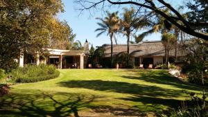 a house with a large yard with trees and grass at Lourie Lodge in Johannesburg
