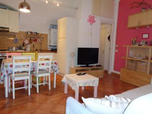 een woonkamer met een tafel en stoelen en een televisie bij Apartment Medieval Village in Isolabona