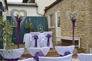 une table mise en place pour un mariage avec des archets violets et violets dans l'établissement Pension Mair, à Stetten