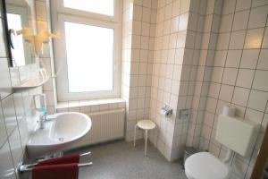 baño con lavabo y aseo y ventana en Hotel Burgk, en Dresden