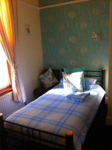 a bedroom with a bed with a blue and white blanket at Seahaven House in Ryde