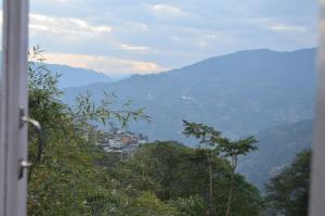 a view of a mountain with a town in the distance at Jagjeet's Sikkim Retreat in Gangtok +36 photos