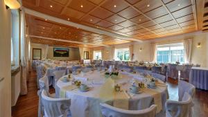 una sala banchetti con tavoli e sedie bianchi di Pension Mair a Stetten