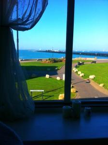 a window with a view of a field and the ocean at Seahaven House in Ryde