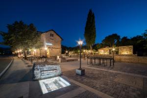 a square with tables and lights at night at Hotel Stanica Ravno in Ravno