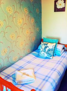 a bedroom with a bed with a blue and white bedspread at Seahaven House in Ryde