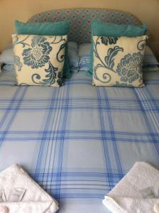 a bed with blue and white sheets and pillows at Seahaven House in Ryde