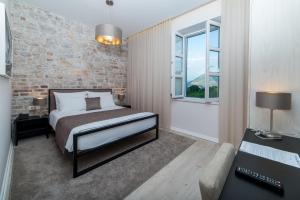 a bedroom with a bed and a brick wall at Hotel Stanica Ravno in Ravno