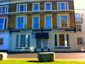a large brick building with blue windows at Seahaven House in Ryde