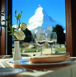 two glasses of white wine sitting on a table at Riffelalp Resort 2222m in Zermatt