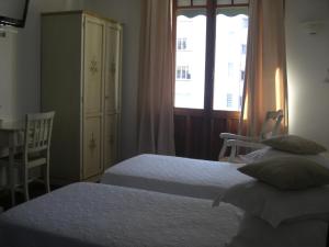 a bedroom with two beds and a window at La Marjolaine in Juan-les-Pins