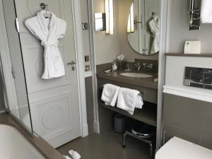 a bathroom with a sink and a toilet and a mirror at Hôtel Recamier in Paris